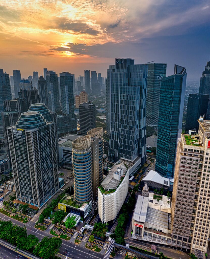 Dramatic sunset over Jakarta's skyline, highlighting its modern skyscrapers and urban landscape.