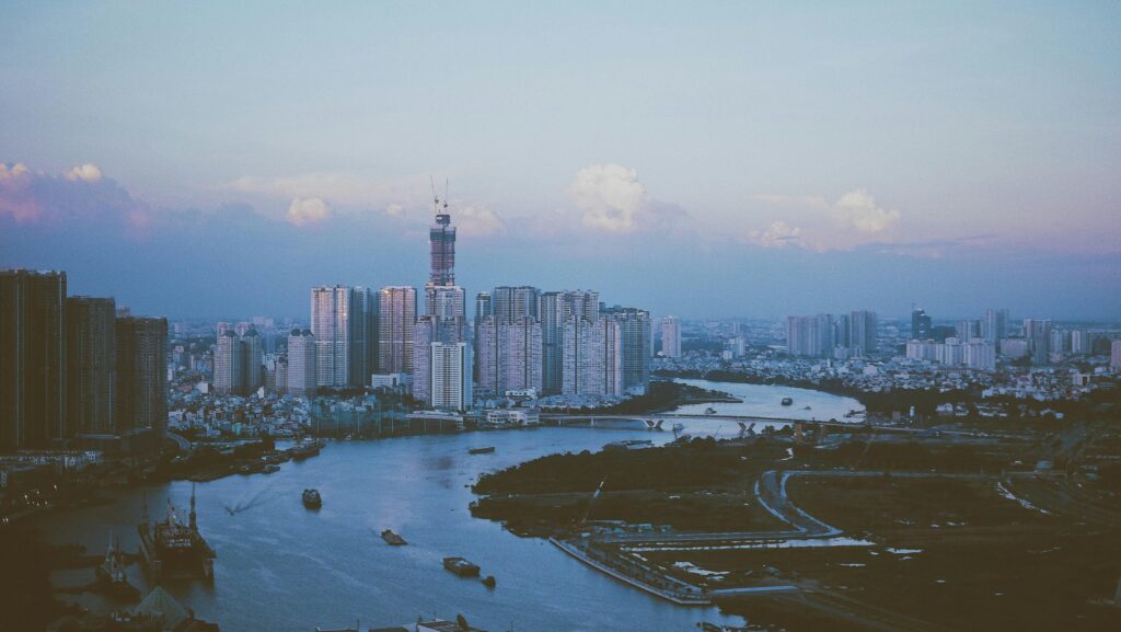 Stunning dusk view of Ho Chi Minh City skyline reflecting on the Saigon River's calm waters.