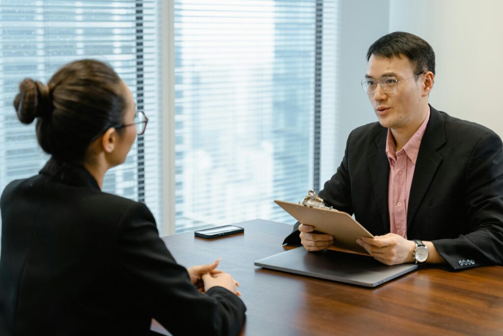 Two professionals discussing at an office table, indicating a formal meeting setting.